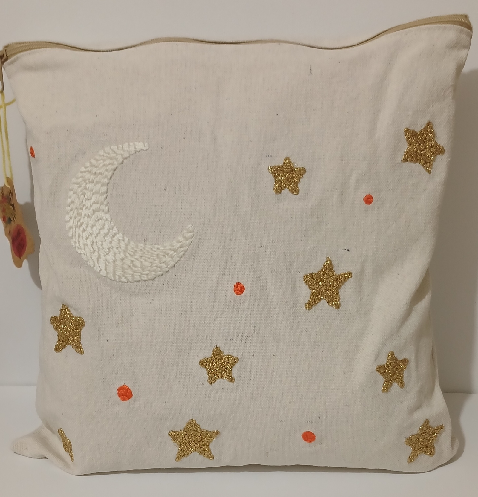 White punch needle cushion with a white crescent and golden stars