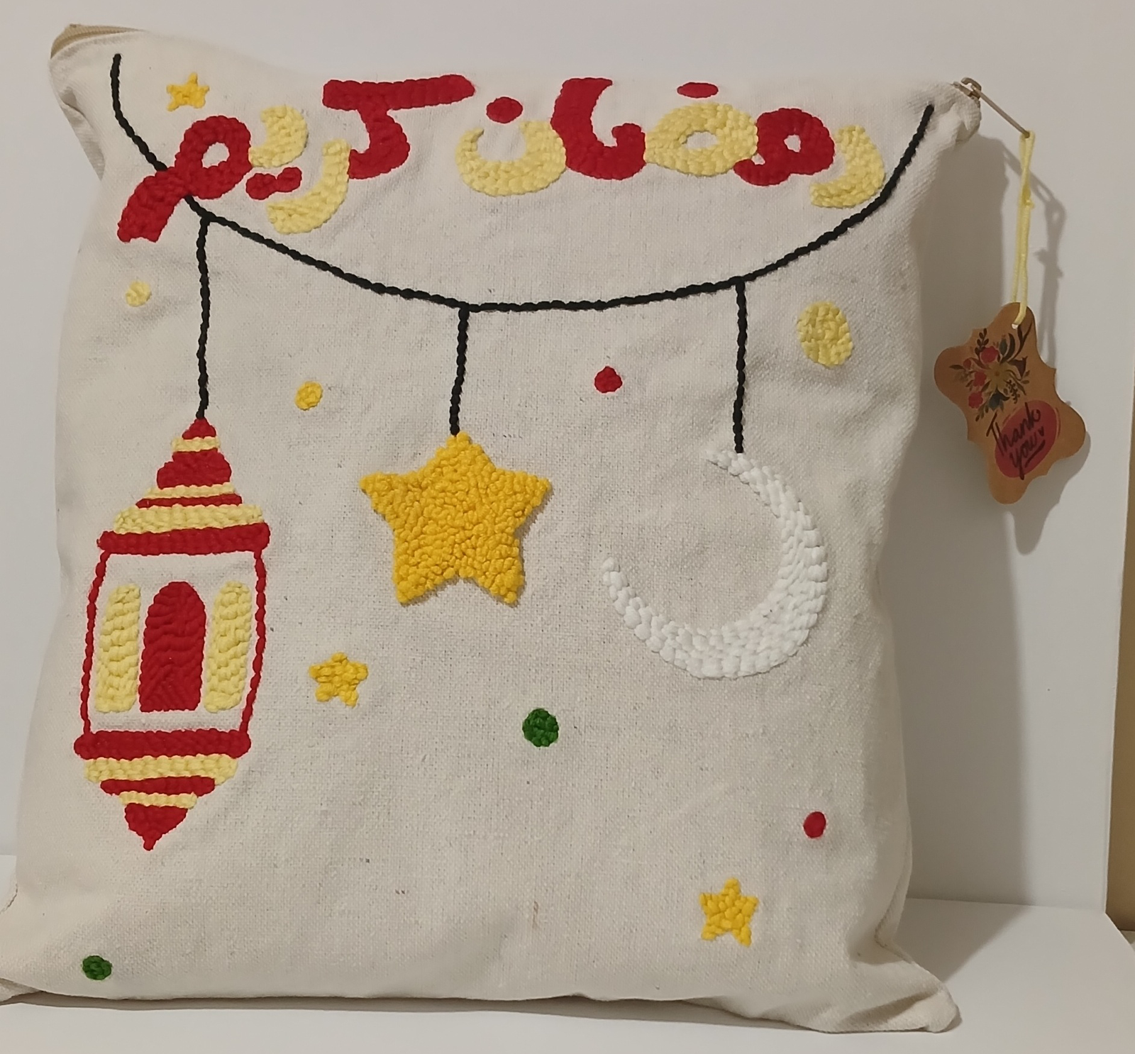 White punch needle cushion with Ramadan Kareem lettering, lantern, crescent and star